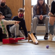 Mokiniai ritinėja margučius